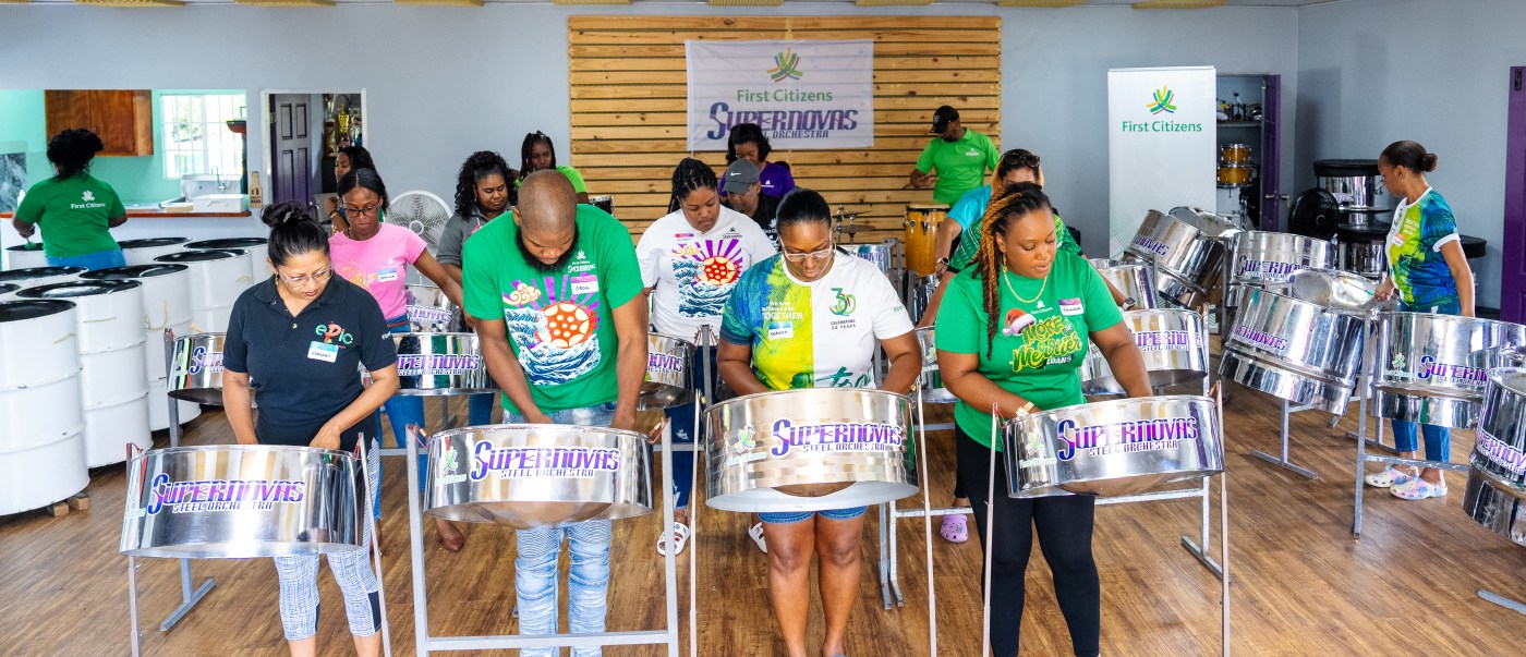 Staff members of First Citizens engaged in learning the basics of the steelpan during the "Play ah Pan" Workshop